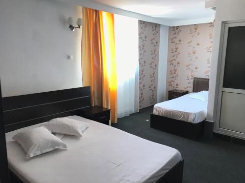 ein Hotelzimmer mit 2 Betten und einem Fenster in der Unterkunft Casa Ardeleană in Ploieşti