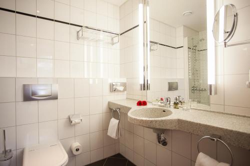 a white bathroom with a sink and a toilet at Aparion Apartments Berlin in Berlin