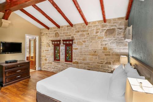 a bedroom with a bed and a stone wall at Econo Lodge Hotel Brossard in Brossard