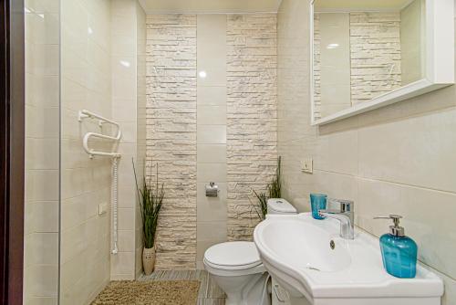 y baño con aseo blanco y lavamanos. en Apartamentai 555, en Vilna