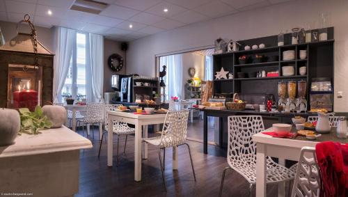 a kitchen with tables and chairs in a room at Hôtel des Alpes in Annecy