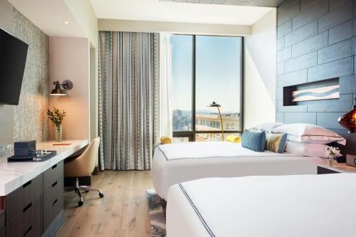 a hotel room with two beds and a desk at Kimpton Hotel Arras by IHG in Asheville
