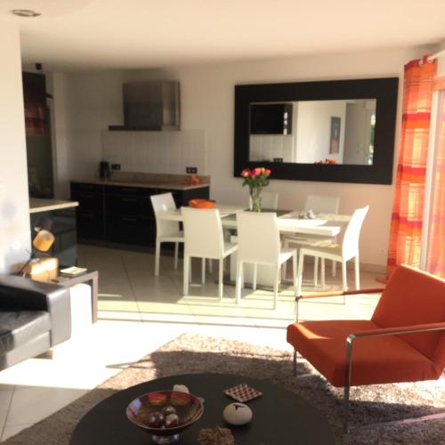 un salon avec une table et une cuisine dans l'établissement Sea view apartment, à Marseillan