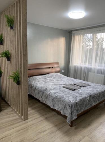 um quarto com uma cama e uma janela em Babylon Apartments on Vidinska 41 em Rivne