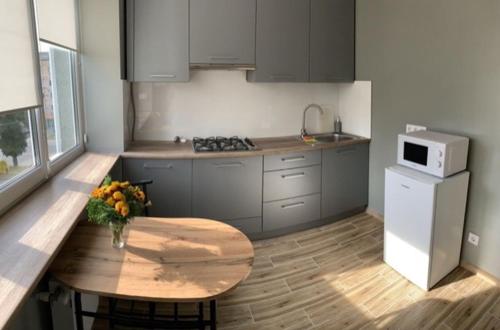 uma cozinha com uma mesa de madeira e um frigorífico branco em Babylon Apartments on Vidinska 41 em Rivne