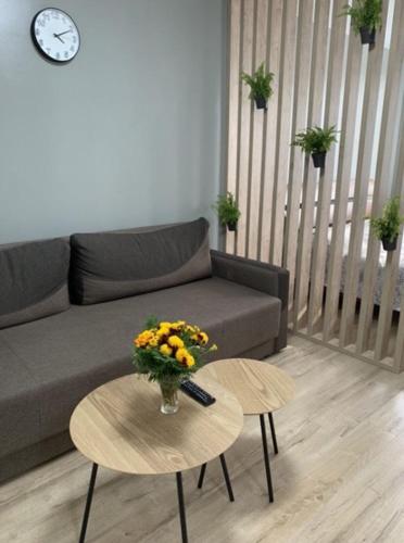 uma sala de estar com um sofá e uma mesa com flores em Babylon Apartments on Vidinska 41 em Rivne