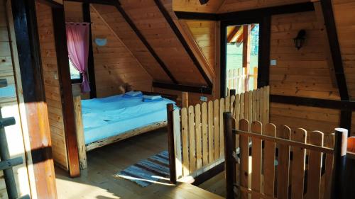 Habitación con cama en una cabaña de madera en Brvnara Dolina jela, en Bajina Bašta