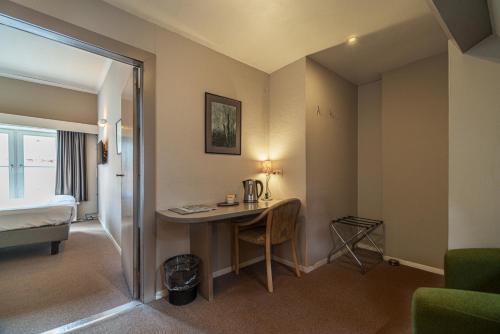 a hotel room with a desk and a bed at Hotel Bourgoensch Hof in Bruges
