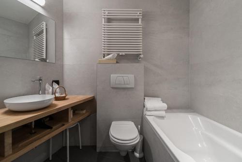 a bathroom with a sink and a toilet and a tub at Hotel Bourgoensch Hof in Bruges