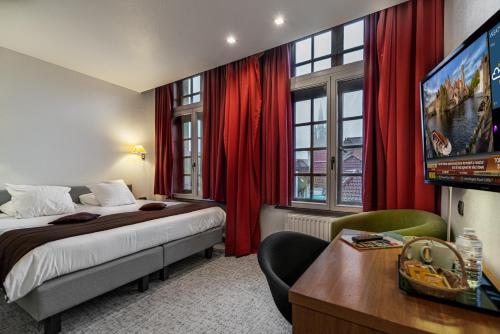 a hotel room with a bed and a flat screen tv at Hotel Bourgoensch Hof in Bruges