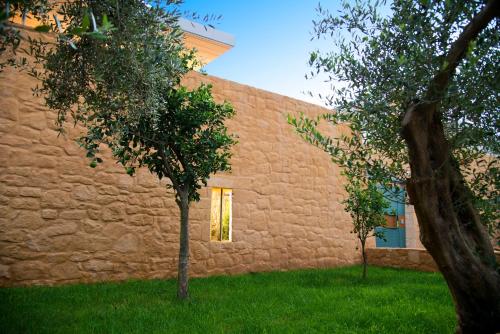 a brick building with two trees in front of it at Conte Marino Villas in Maleme