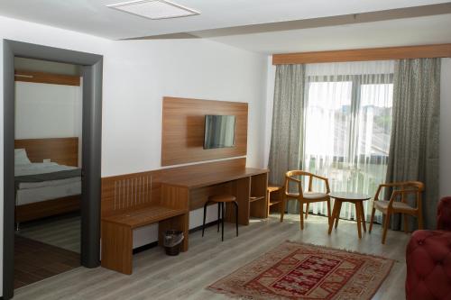 泰基爾達的住宿－BUSINESS EXPRESS HOTEL，酒店客房设有书桌和卧室。