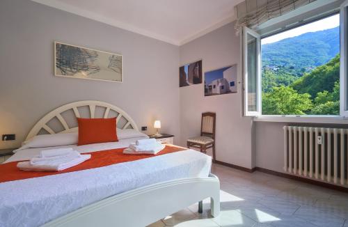um quarto com uma cama e uma grande janela em Apartment Varenna Dream em Varenna