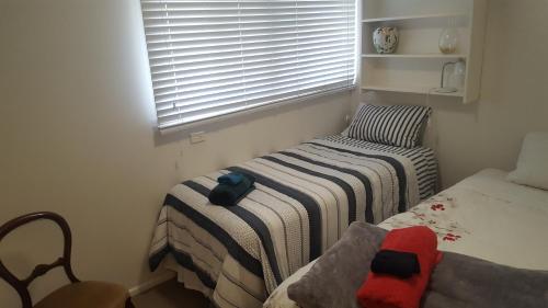 a small room with two beds and a window at Gateway to the Surf Coast and Geelong in Geelong