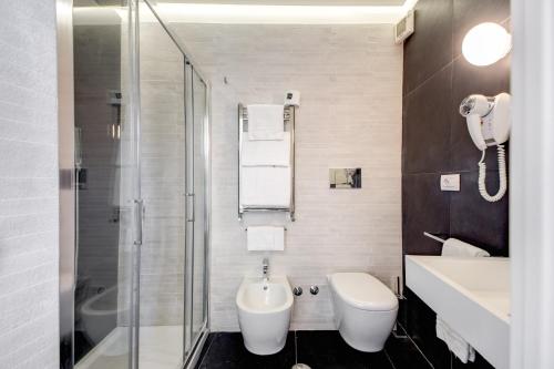 a bathroom with a toilet and a sink and a shower at Albergo Abruzzi in Rome