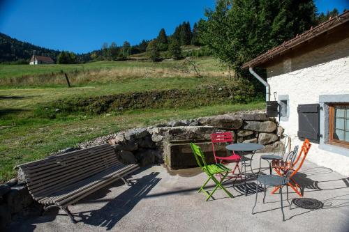 a group of chairs and a bench next to a building at La Ferme du Douanier & Spa 5 étoiles ALL INCLUSIVE in Ventron
