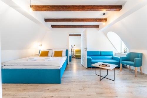 a bedroom with a blue bed and blue chairs at Villa Wurmfeld in Český Krumlov