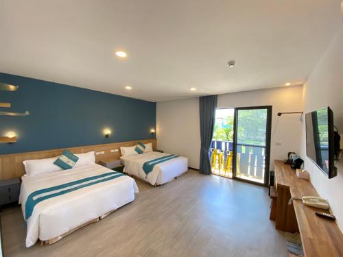 a hotel room with two beds and a television at Kenting Sunhow Inn in Kenting