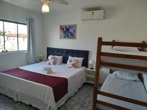a bedroom with a bed and a bunk bed at Pousada Elegance Beira Mar in Itanhaém