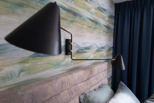 a black lamp on a wall with a painting at B&B Doremi in Kaatsheuvel