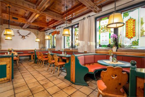 un restaurante con mesas, sillas y vidrieras en Hotel Böhmerwaldhof, en Ulrichsberg
