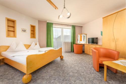 ein Hotelzimmer mit einem Bett und einem Stuhl in der Unterkunft Hotel Böhmerwaldhof in Ulrichsberg