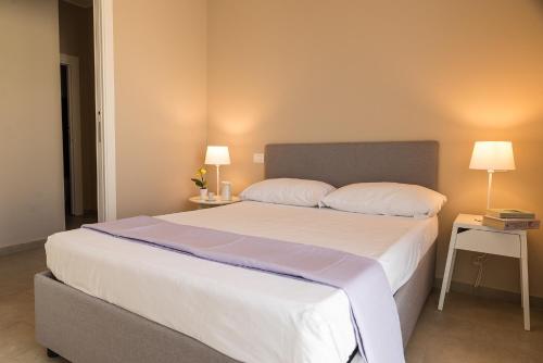 マッゼオにあるCavalluccio Marinoのベッドルーム(白い大型ベッド、ランプ2つ付)