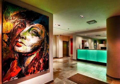 a large painting of a woman on a wall in a lobby at ProfilHotels President in Norrköping