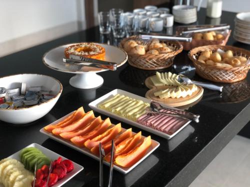a buffet with many different types of food on a table at NAIM Hotel Capitólio in Capitólio