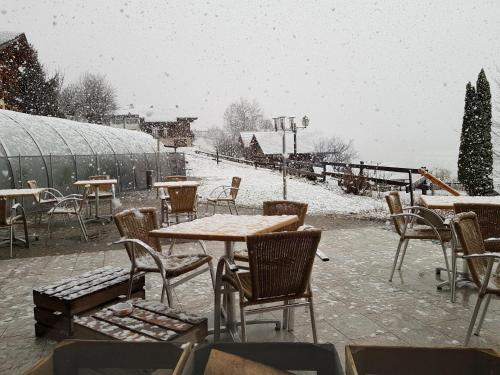 a patio with tables and chairs in the snow at Le Chabi in La Chapelle-dʼAbondance