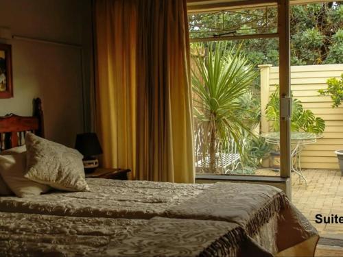 a bedroom with a bed and a large window at 21Benade in Bloemfontein