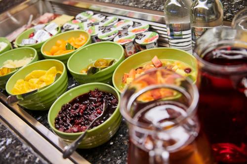 a buffet with bowls of food and a drink at Holiday Inn Ellesmere Port/Cheshire Oaks, an IHG Hotel in Ellesmere Port