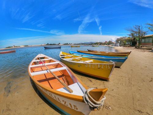 a group of boats sitting on the beach at Pousada Figueira in Guarda do Embaú