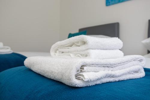sterta ręczników na łóżku w obiekcie Stopover at LOWCAY APARTMENT C great for workers and groups w mieście Portsmouth
