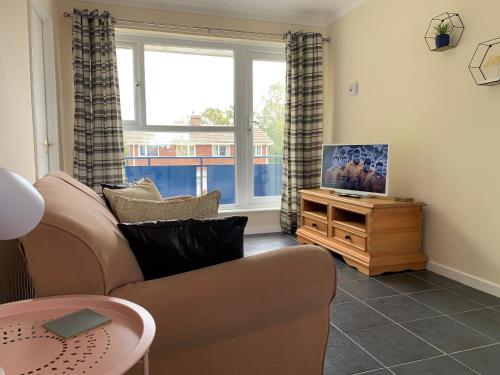 a living room with a couch and a tv on a table at Stay Seaton Delaval in Seaton Delaval