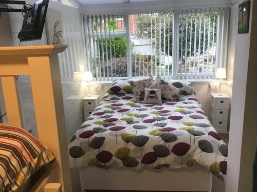 um quarto com uma cama com um edredão em Apps B&B em Poole