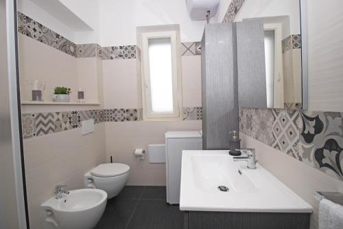 a white bathroom with a sink and a toilet at Puglia casa vacanza in Ginosa Marina