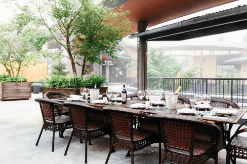 a large wooden table with chairs and wine glasses at HOTEL KARUIZAWA CROSS in Karuizawa