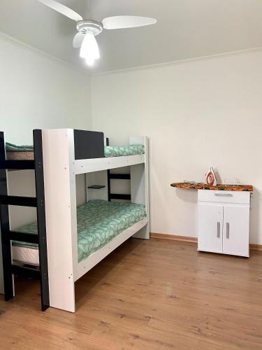 a white bunk bed in a room with a table at Apto Temp itapira e circuito das águas EUROVILE in Itapira