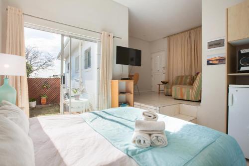 a bedroom with a bed with two towels on it at 20AB Belladonna Apartments Vredehoek Cape Town in Cape Town