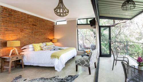 a bedroom with a bed and a brick wall at Nehema Manor in Hartbeespoort