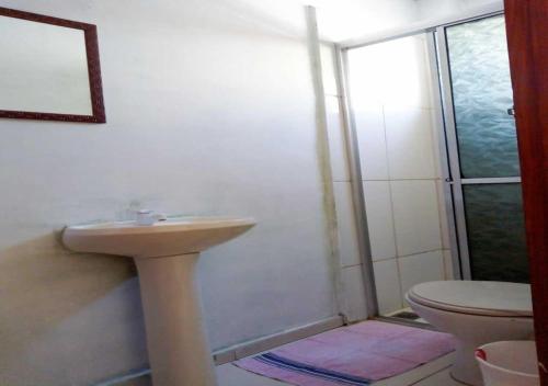 a bathroom with a sink and a toilet at Pousada Brasil - Self Check-in in Aparecida