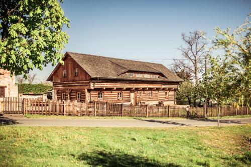 an old wooden building with a fence in front of it at Roubenka u Huvarů in Tachov