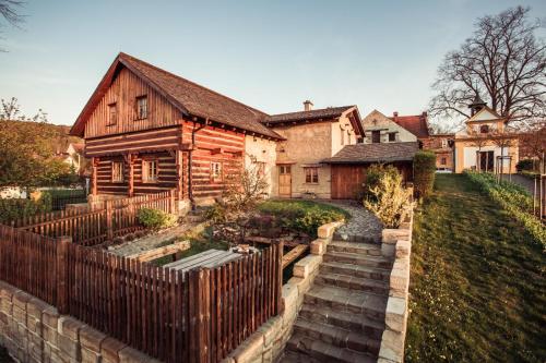 an old house with a wooden fence in front of it at Roubenka u Huvarů in Tachov