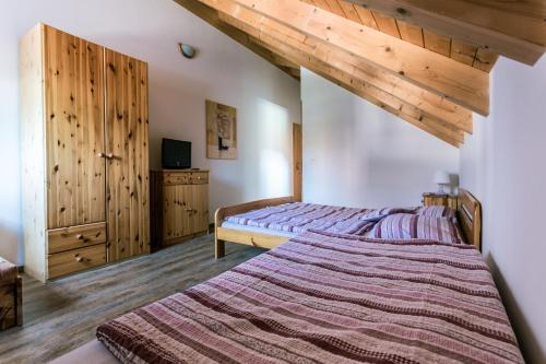 a bedroom with a bed and a wooden ceiling at Roubenka u Huvarů in Tachov