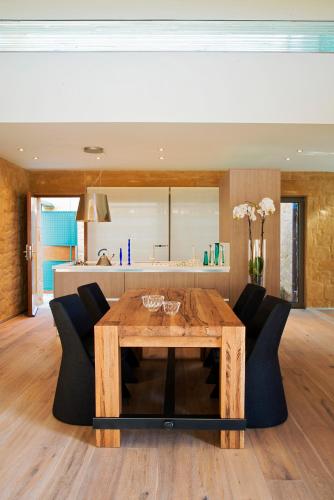 a dining room with a wooden table and black chairs at Conte Marino Villas in Maleme