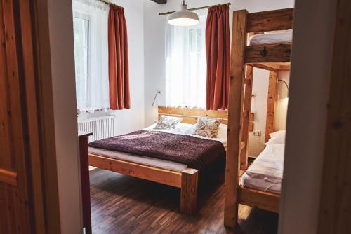 a bedroom with two bunk beds and two windows at Apartmány Na Faře in Bílá