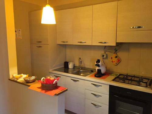 een keuken met witte kasten, een wastafel en een fornuis bij CasaSylvia in Cassano delle Murge