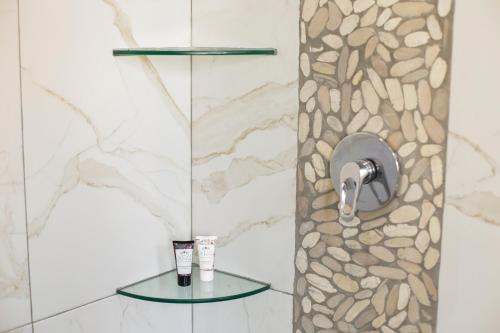 a bathroom with a shower with a stone wall at Casa Korima Cancun - Luxurious - Budget Friendly in Cancún