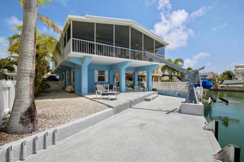 a house on the water with a palm tree at Tarpon Cove in Tavernier